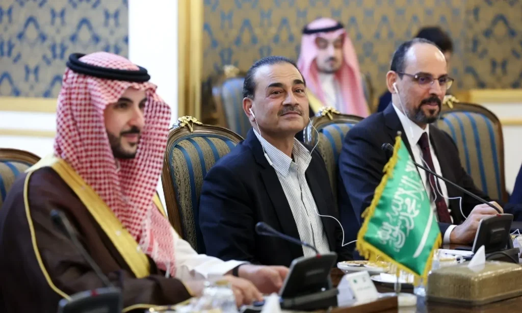 Saudi, Pakistani and Turkish delegates seated beneath a Saudi flag at the Makkah pact talks in Tehran