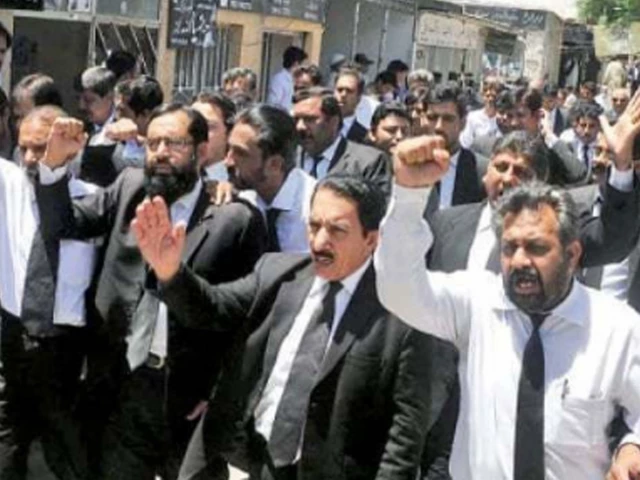 Lawyers in black coats marching with raised fists outside a court as lawyers boycott courts over governor's rule